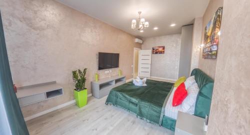 a bedroom with a green bed and a tv at PEARL PREMIUM APARTMENTS 2 in Kyiv