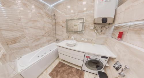 a bathroom with a sink and a washing machine at PEARL PREMIUM APARTMENTS 2 in Kyiv