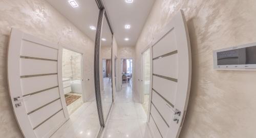 a hallway with two white doors and a mirror at PEARL PREMIUM APARTMENTS 2 in Kyiv
