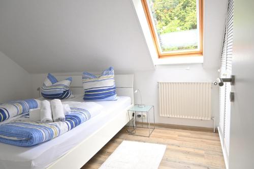 a white room with a bed with blue and white pillows at Fewo, Nähe Dieksee in Malente