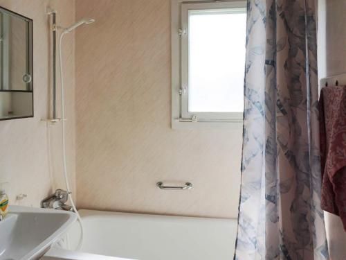 baño con ducha, lavabo y ventana en Apartment VISBY II, en Visby