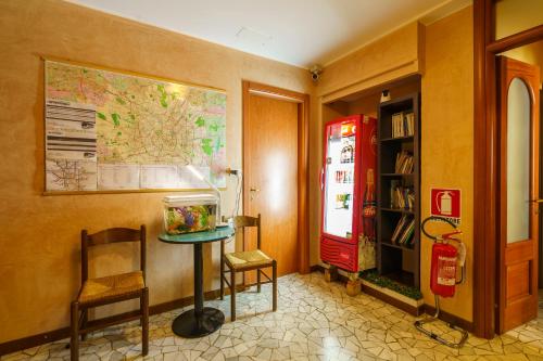 a room with a red refrigerator and a table and chairs at Hotel America in Milan