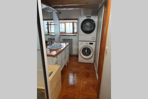 a bathroom with a washing machine and a washer and dryer at Maison individuelle chaleureuse au calme in Bourg-Saint-Maurice