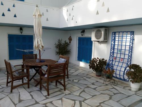 patio con tavolo, sedie e ombrellone di Agnes Rooms a Kinion