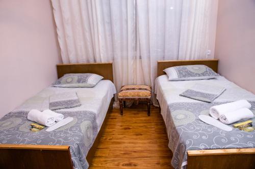 two twin beds in a room with curtains at Mini House in Alaverdi