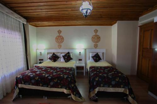 a bedroom with two beds and a chandelier at Bacchus Pension in Antalya