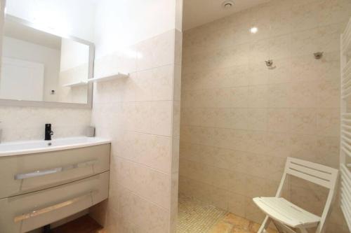 ein Badezimmer mit einem Waschbecken und einem Stuhl darin in der Unterkunft Gîte avec jacuzzi à 30min du Puy Du Fou in Saint-Macaire-en-Mauges