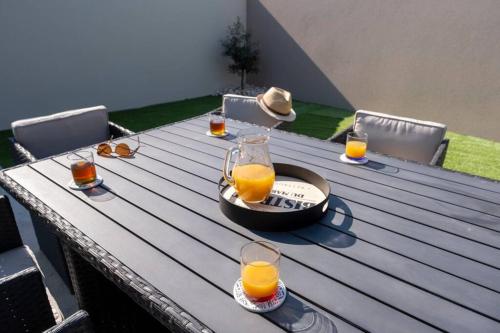 - une table en bois avec des verres de jus d'orange dans l'établissement Gîte avec jacuzzi à 30min du Puy Du Fou, à Saint-Macaire-en-Mauges