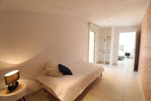 une chambre avec un lit et une lampe sur une table dans l'établissement Gîte avec jacuzzi à 30min du Puy Du Fou, à Saint-Macaire-en-Mauges