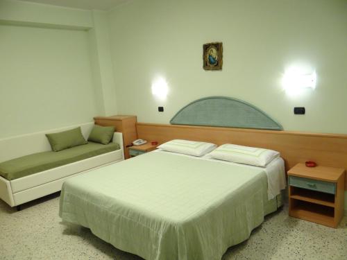 una camera d'albergo con letto e divano di Hotel Aquila D'Oro a Misano Adriatico