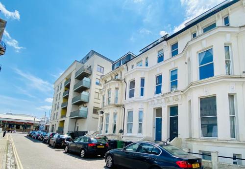 a row of cars parked in front of a building at Ann Apartments opposite the Pier with sea view in Portsmouth