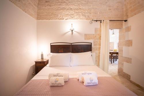 een slaapkamer met een bed met 2 kussens erop bij WePuglia - Trullo Sentimento in Martina Franca