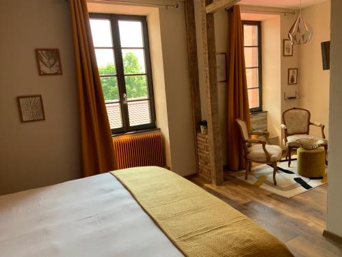 1 dormitorio con cama, ventana y silla en Les Chambres - Au Grès du marché en La Petite-Pierre
