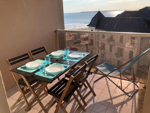une table et des chaises sur un balcon avec vue sur la plage dans l'établissement LES CEDRES, Résidence LES OCEANES, à Pornichet