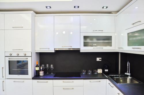 a white kitchen with white cabinets and a sink at Uvac lake "FF" in Sjenica