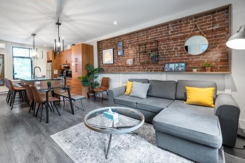a living room with a couch and a brick wall at Montreal Styled 2 BR Apartment on St-Denis Street in Montréal