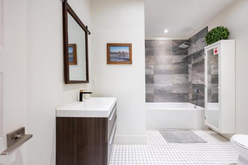 a bathroom with a sink and a toilet and a tub at Montreal Styled 2 BR Apartment on St-Denis Street in Montréal