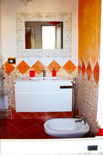 ein Badezimmer mit einem weißen Waschbecken und einem Spiegel in der Unterkunft Villa Marina in Orosei