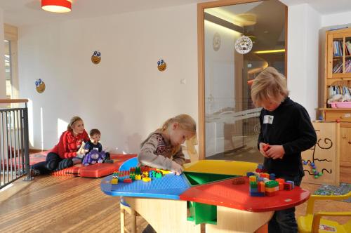 a group of children playing with a table in a room at Familien- Sportresort BRENNSEEHOF in Feld am See