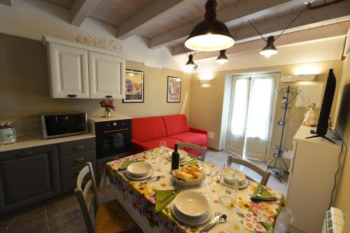 a kitchen and living room with a table and a red couch at La Beppa - Casa Vacanza in Pontremoli