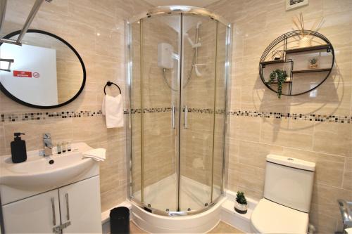 a bathroom with a shower and a toilet and a sink at Northcote Lane Apartments - By Property Promise in Cardiff