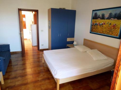 a bedroom with a bed and a painting on the wall at Residence Covo degli Dei in Milazzo