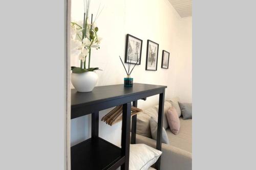 a black console table in a room with a couch at cute studio rom in Mons