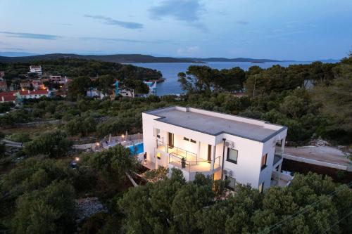 uma vista aérea de uma casa branca com uma piscina em Luxury Apartments Mauro with Heated Pool em Božava