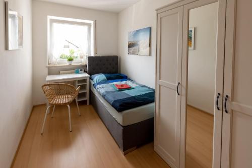 - une petite chambre avec un lit et un bureau dans l'établissement Ferienwohnung Chiemsee, à Unterneukirchen