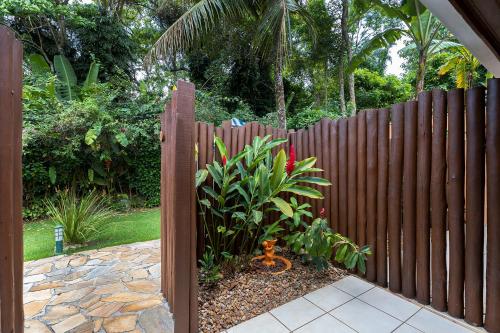 a wooden fence with a plant in a garden at Hotel Ilhasol in Ilhabela