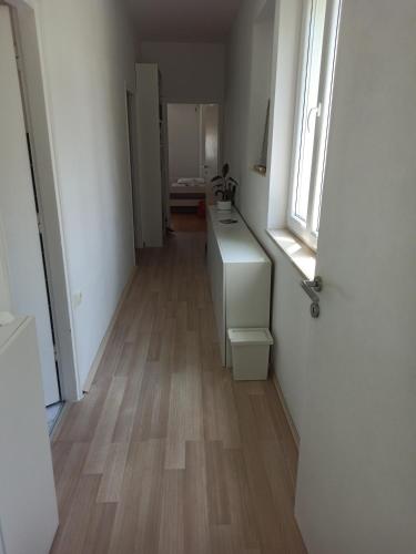 a hallway with a bathroom with a sink and a window at NoAr Apartment Rijeka in Rijeka