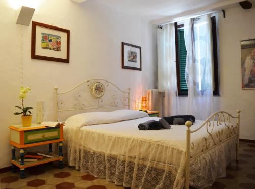 una camera con un letto bianco e una finestra di Domus Lucca a Lucca