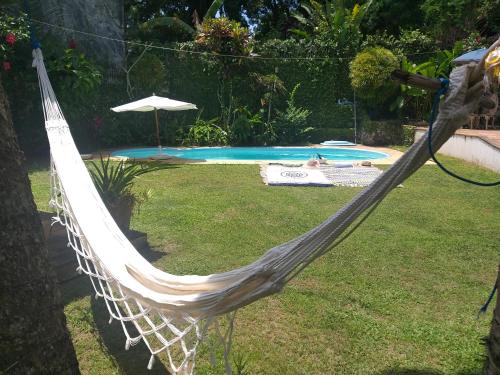 a hammock in a yard next to a pool at Pousada Almaviva in Ilha de Boipeba