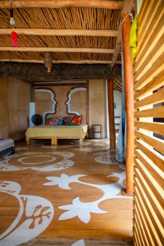 a room with a bed and a wooden floor at Casa Love in Sayulita