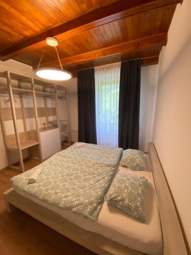- une chambre avec un lit et un plafond en bois dans l'établissement Apartment Nona Polda, à Kobarid