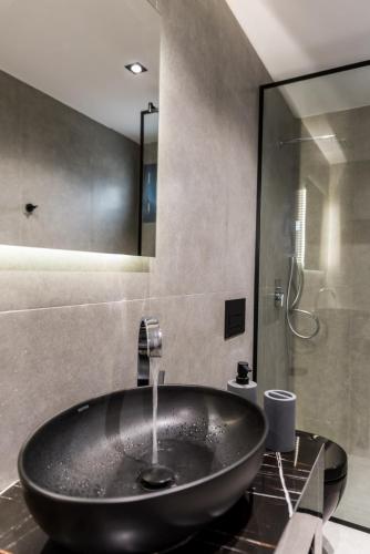 a bathroom with a black sink and a shower at Poseidon close to the beach in Agios Nikolaos