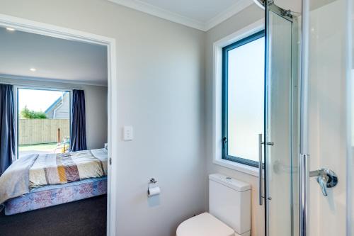 a bedroom with a bed and a window at SeaRenity - Waimarama Holiday Home in Waimarama