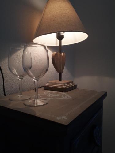 dos copas de vino sentadas en una mesa con una lámpara en Il Cavalluccio Marino en Manarola