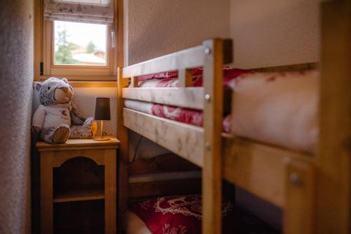 mały pokój z 2 łóżkami piętrowymi i pluszowym misiem w obiekcie Les Alpages 73 - Les Saisies w mieście Les Saisies