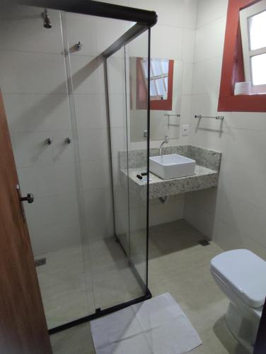 a bathroom with a shower and a sink and a toilet at Pousada Portas da Lua in Catas Altas
