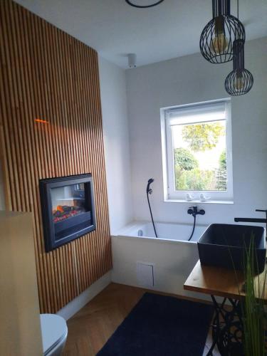 a bathroom with a bath tub and a window at Apartamenty Sielanka in Olecko