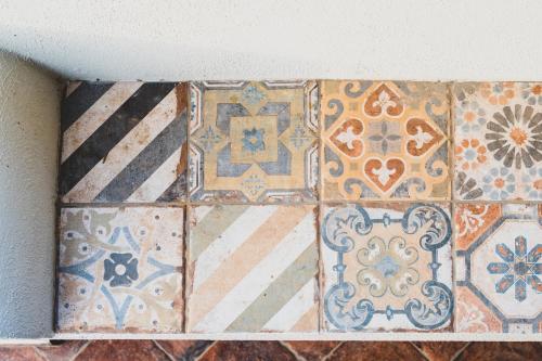 un montón de diferentes tipos de azulejos en una pared en Il Limoneto Rooms, en Terme Vigliatore