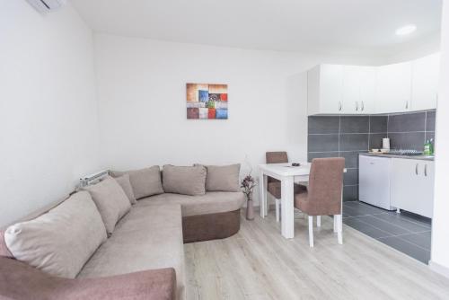 ein Wohnzimmer mit einem Sofa und einem Tisch in der Unterkunft Apartmani Centar Loznica in Loznica