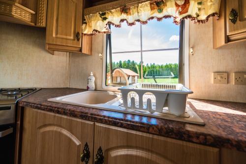 a kitchen counter with a sink and a window at Domek na skraju Lasu Kruklanki Mazury in Kruklanki