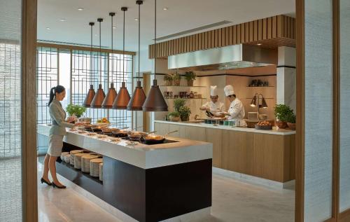 a kitchen with three chefs preparing food in a kitchen at Shangri-La Singapore in Singapore