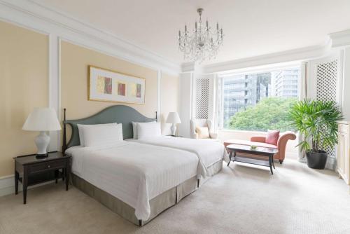 a white bedroom with a large bed and a chandelier at Shangri-La Singapore in Singapore