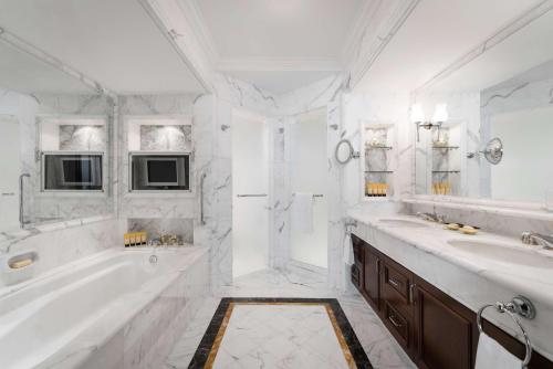 a white bathroom with a tub and a sink at Shangri-La Singapore in Singapore
