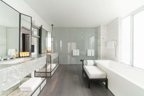 a white bathroom with two sinks and a tub at Shangri-La Singapore in Singapore