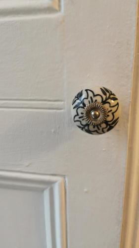 a door knob on a white door with a flower on it at The Old Exchange in Clifden