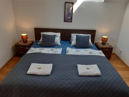 1 dormitorio con 1 cama azul grande y 2 almohadas en apartman Happy, en Stará Lesná